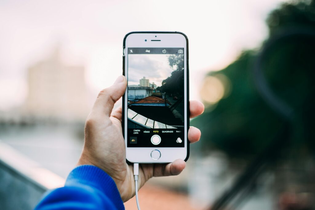 iPhone user capturing photo during golden hour